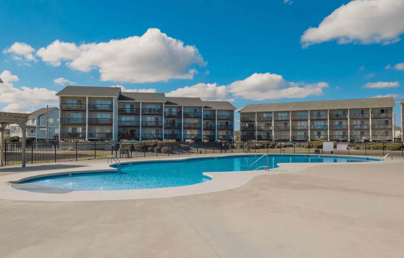 The Surf Condos community pool with the two oceanfront condo buildings behind it, Surf City