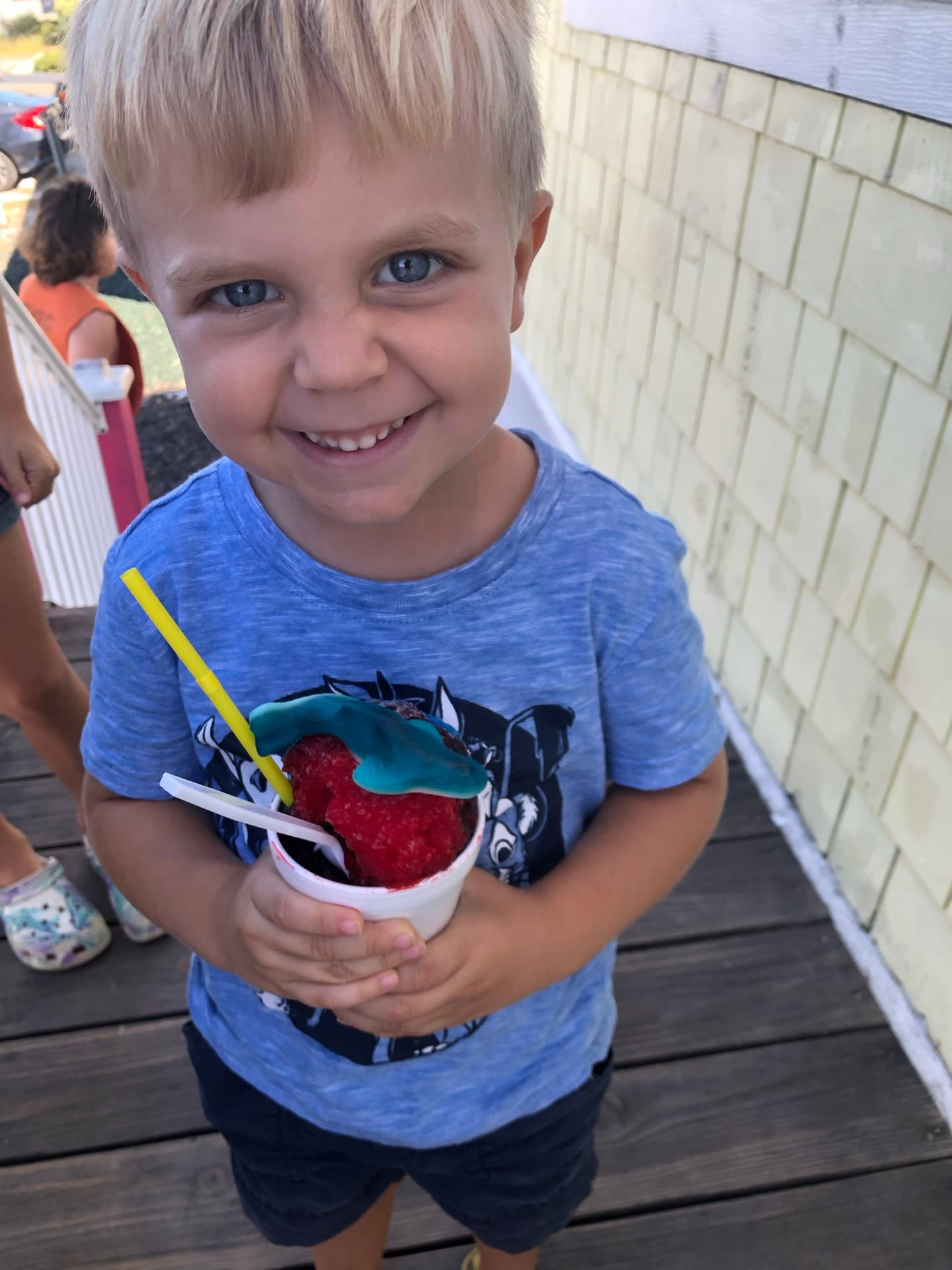 A kid mid-summer holding a snow cone on Topsail